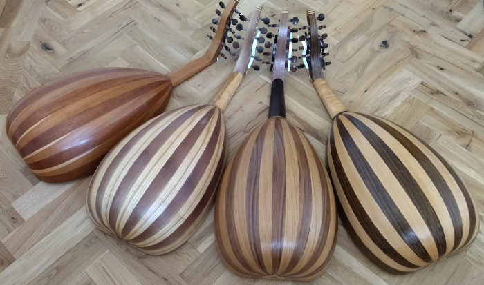 Back view of 4 Shahed model ouds. Bodies of [L-R] European Cherry and Sapele, European Ash and European Walnut, European Oak and European Walnut, Ovangkol and European Beech.
